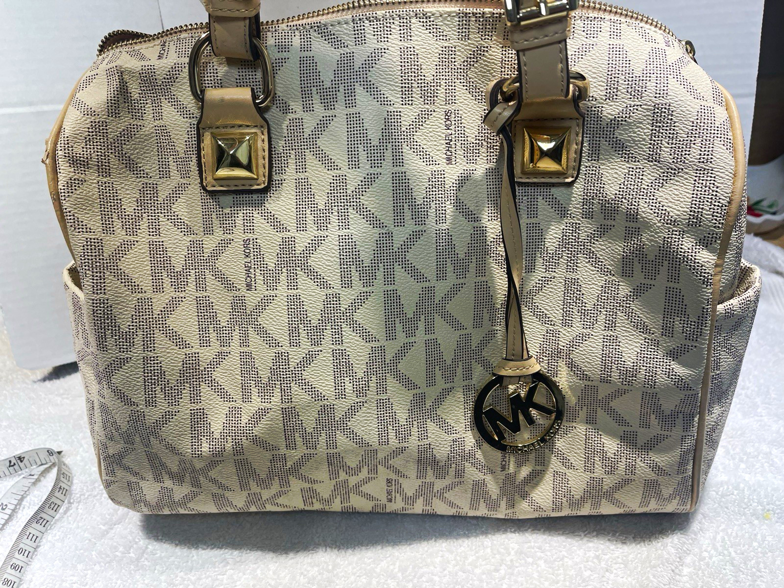 beige Michael Kors Grayson satchel features the brand’s signature monogram print