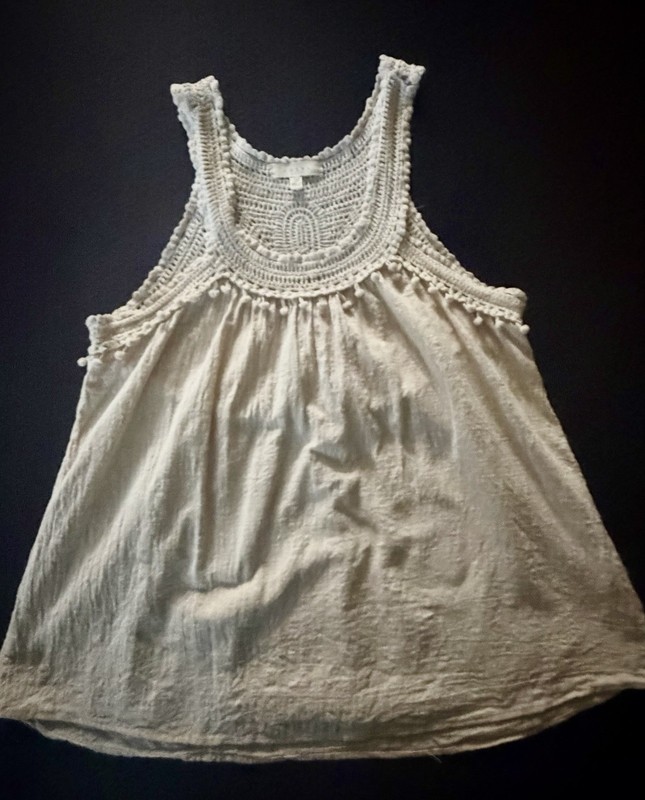 Adiva cream sleeveless top featuring a distinctive crochet yoke and pom-pom trim